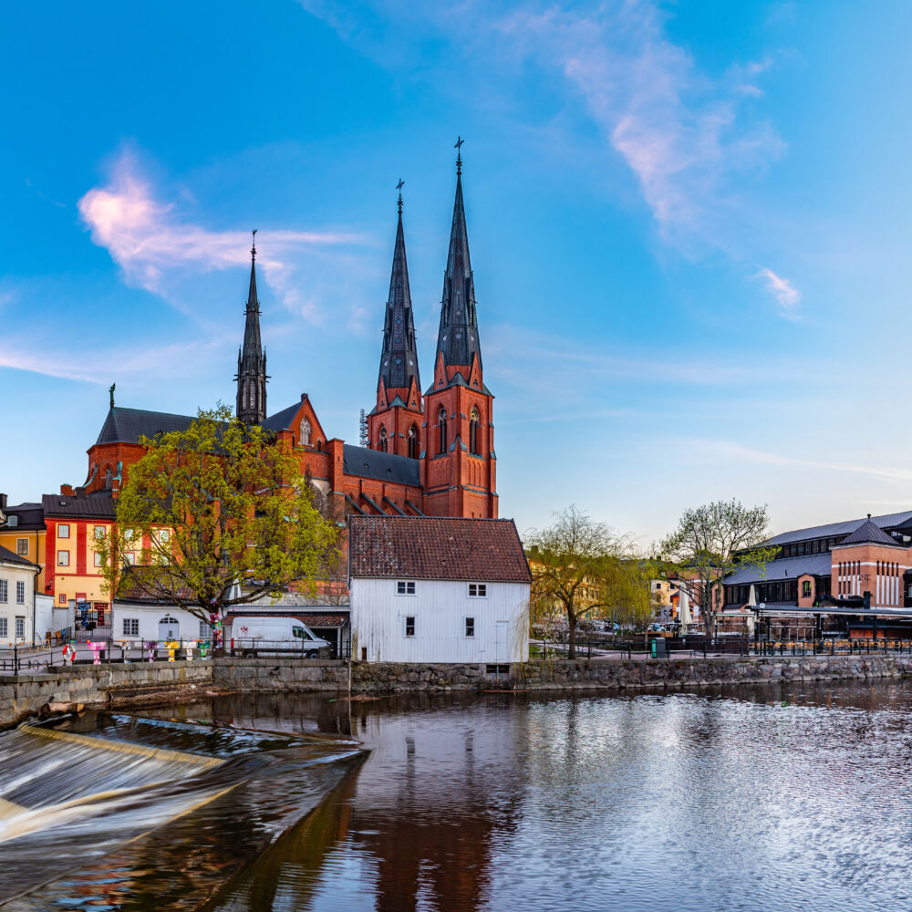 Sunset view of white building of Uppland museum and cathedral in Uppsala, Sweden